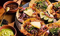Mexican catering taco bar with tortillas, fillings, salsa and guacamole