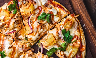 Open boxes of catering pizzas cut into slices for a group